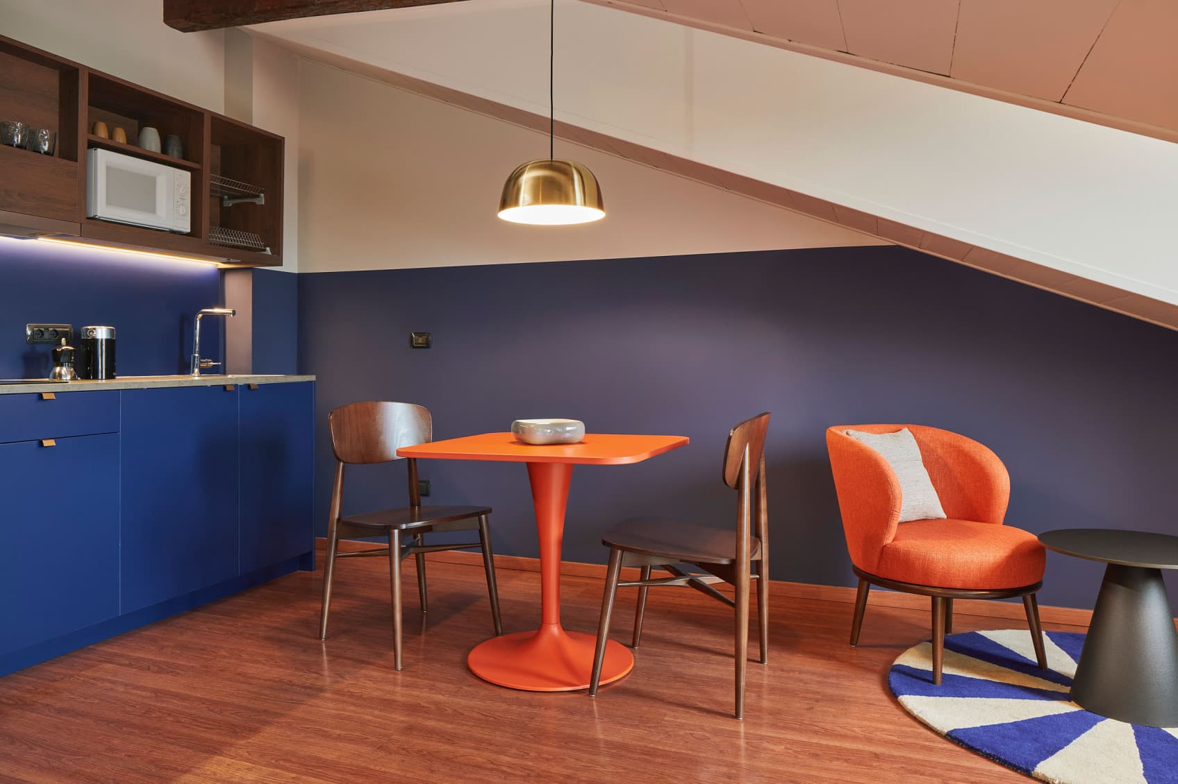 Cozy Studios room 605, view of the living area with kitchen and dining table directly under the roof